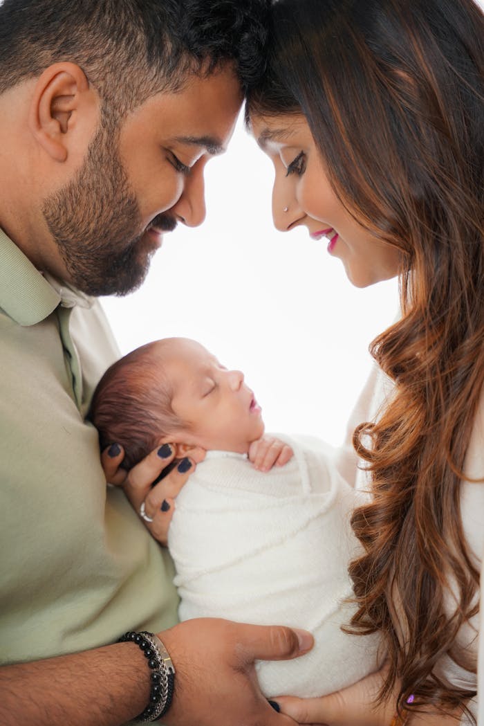 Happy South Asian Family with Newborn Baby: Tender Studio Portrait