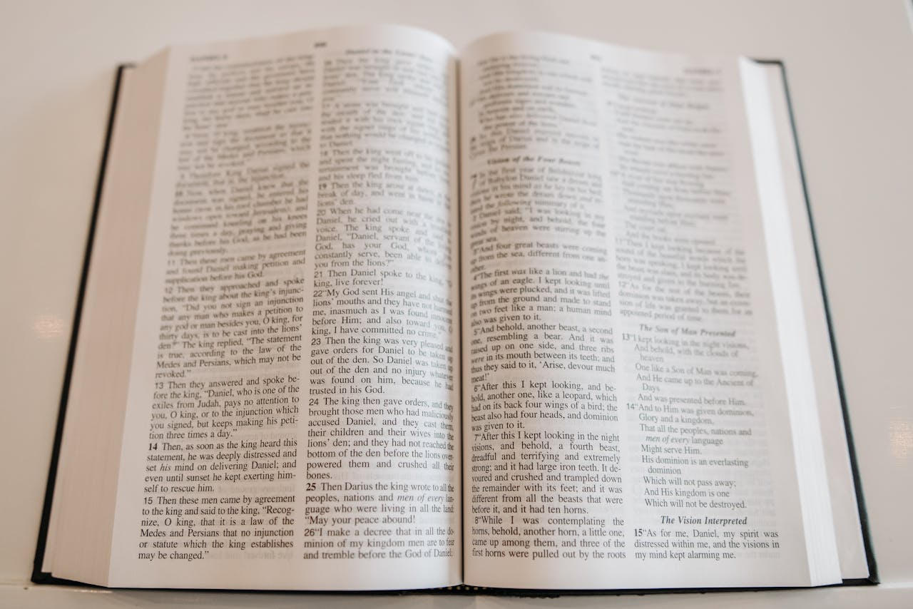 An open Holy Bible on a wooden table, showcasing scripture text, ideal for religious and spiritual themes.